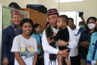 Menko Muhadjir saat menggendong anak dari pasien yang mau di Puskesmas Labuan Bajo.
