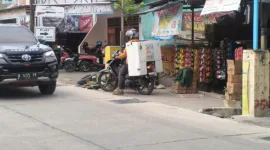 Salah satu warga saat mau melintas dijalan betonisasi yang dikerjakan oleh pemkab Sidoarjo.