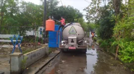 Petugas Delta Tirta mengisi air bersih untuk warga yang terdampak banjir.