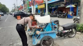 Anggota Samapta Polresta Sidoarjo berikan makanan kepada tukang becak.
