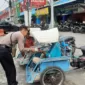Anggota Samapta Polresta Sidoarjo berikan makanan kepada tukang becak.