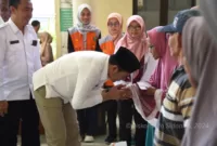 Plt Bupati Subandi Menyerahkan langsung bantuan pangan beras kepada seorang guru ngaji di Krian.