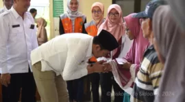 Plt Bupati Subandi Menyerahkan langsung bantuan pangan beras kepada seorang guru ngaji di Krian.