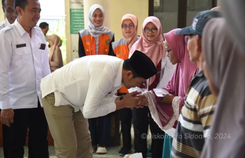 Plt Bupati Subandi Menyerahkan langsung bantuan pangan beras kepada seorang guru ngaji di Krian.