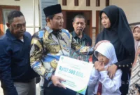 Iva Yuniarsih istri almarhum Kepala Dusun Simpang terima santunan JKM dan beasiswa pendidikan yang diserahkan langsung oleh Plt Bupati Sidoarjo Subandi.