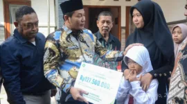 Iva Yuniarsih istri almarhum Kepala Dusun Simpang terima santunan JKM dan beasiswa pendidikan yang diserahkan langsung oleh Plt Bupati Sidoarjo Subandi.