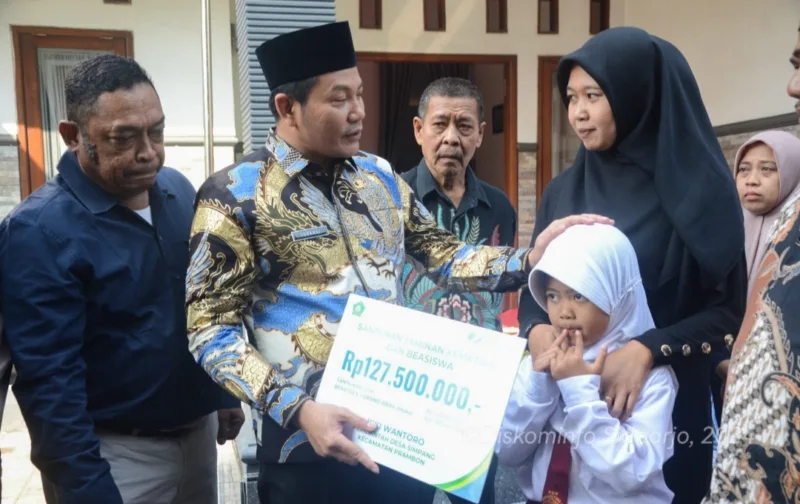 Iva Yuniarsih istri almarhum Kepala Dusun Simpang terima santunan JKM dan beasiswa pendidikan yang diserahkan langsung oleh Plt Bupati Sidoarjo Subandi.