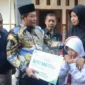 Iva Yuniarsih istri almarhum Kepala Dusun Simpang terima santunan JKM dan beasiswa pendidikan yang diserahkan langsung oleh Plt Bupati Sidoarjo Subandi.