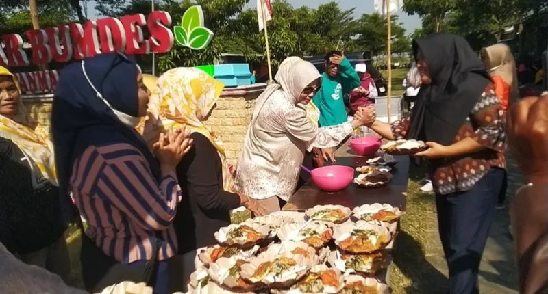 Hj Mimik Idayana Bacawabup Sidoarjo saat bagikan makan gratis kepada warga Desa Pertapan Maduretno Taman, Jum'at (9/8).