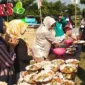Hj Mimik Idayana Bacawabup Sidoarjo saat bagikan makan gratis kepada warga Desa Pertapan Maduretno Taman, Jum'at (9/8).