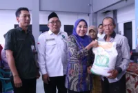 Plt. Ketua TP PKK Kabupaten Sidoarjo Hj. Sriatun secara simbolis serahkan bantuan pangan beras kepada warga di Kecamatan Waru.