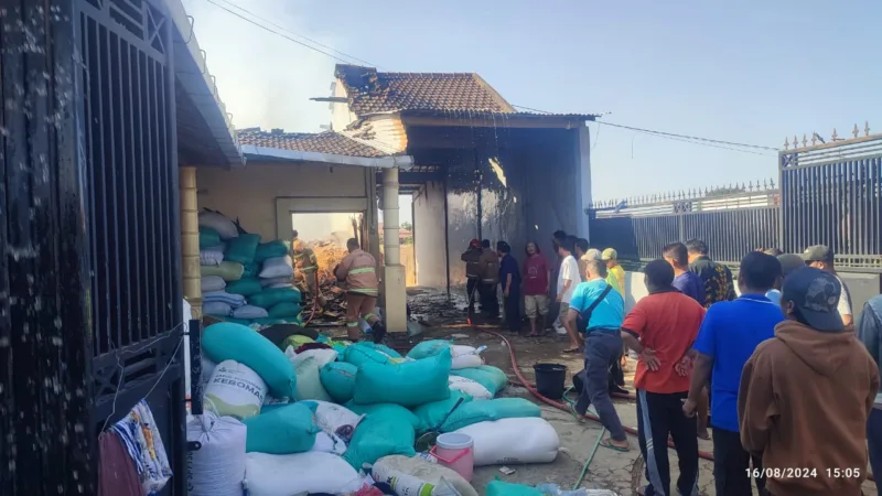 Warga setempat bersama Damkar melakukan pemadaman api di area Gudang padi.