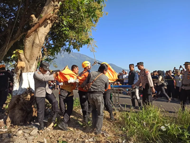 Petugas melakukan upaya evakuasi jasad korban. 