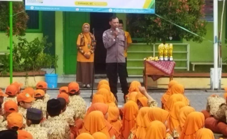 Kanit Binmas Polsek Sedati Polresta Sidoarjo Aiptu Nur Syamsi saarlt berikan edukasi dan bijak bermedia sosial di depan siswa siswi MIN 2, Sedati, Sidoarjo, pada Kamis (1/8/2024).