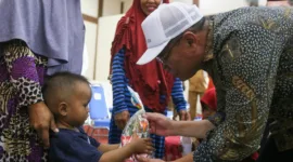 Menko Muhadjir berikan bingkisan kepada anak kecil di Kantor Kecamatan Sepaku, Kabupaten Penajam Paser Utara, Provinsi Kalimantan Timur, pada Senin (12/8/2024).