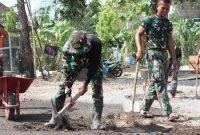 Prajurit Satgas TMMD ke-126 Kodim 0816/Sidoarjo bersama karang taruna dan warga setempat bahu-membahu melakukan pemavingan lapangan voli.