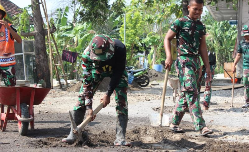Prajurit Satgas TMMD ke-126 Kodim 0816/Sidoarjo bersama karang taruna dan warga setempat bahu-membahu melakukan pemavingan lapangan voli.