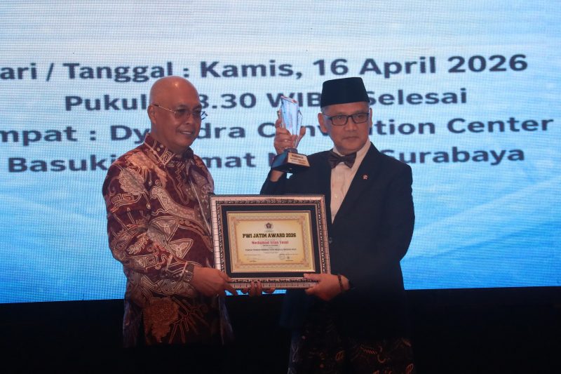 Ketua Umum PWI Pusat Akhmad Munir menyerahkan penghargaan PWI Jatim Award 2026 kepada Menteri Haji dan Umrah RI KH Mochamad Irfan Yusuf Hasyim (Gus Irfan) pada puncak HPN 2026 di Dyandra Convention Center Surabaya, Kamis (16/4/2026).