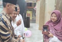 Kepala Desa Sidokepung, Arintono, SE didampingi Ketua RT Hasan Basri sekaligus Ketua Takmir Musholla Al Hikmah menyerahkan doorprize utama kepada Ibu Thohir dalam peringatan Maulid Nabi Muhammad SAW di Musholla Al Hikmah, Selasa (25/8/2026).