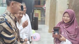 Kepala Desa Sidokepung, Arintono, SE didampingi Ketua RT Hasan Basri sekaligus Ketua Takmir Musholla Al Hikmah menyerahkan doorprize utama kepada Ibu Thohir dalam peringatan Maulid Nabi Muhammad SAW di Musholla Al Hikmah, Selasa (25/8/2026).