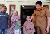 Bupati Sidoarjo Subandi menyerahkan bantuan kursi roda kepada penyandang disabilitas.